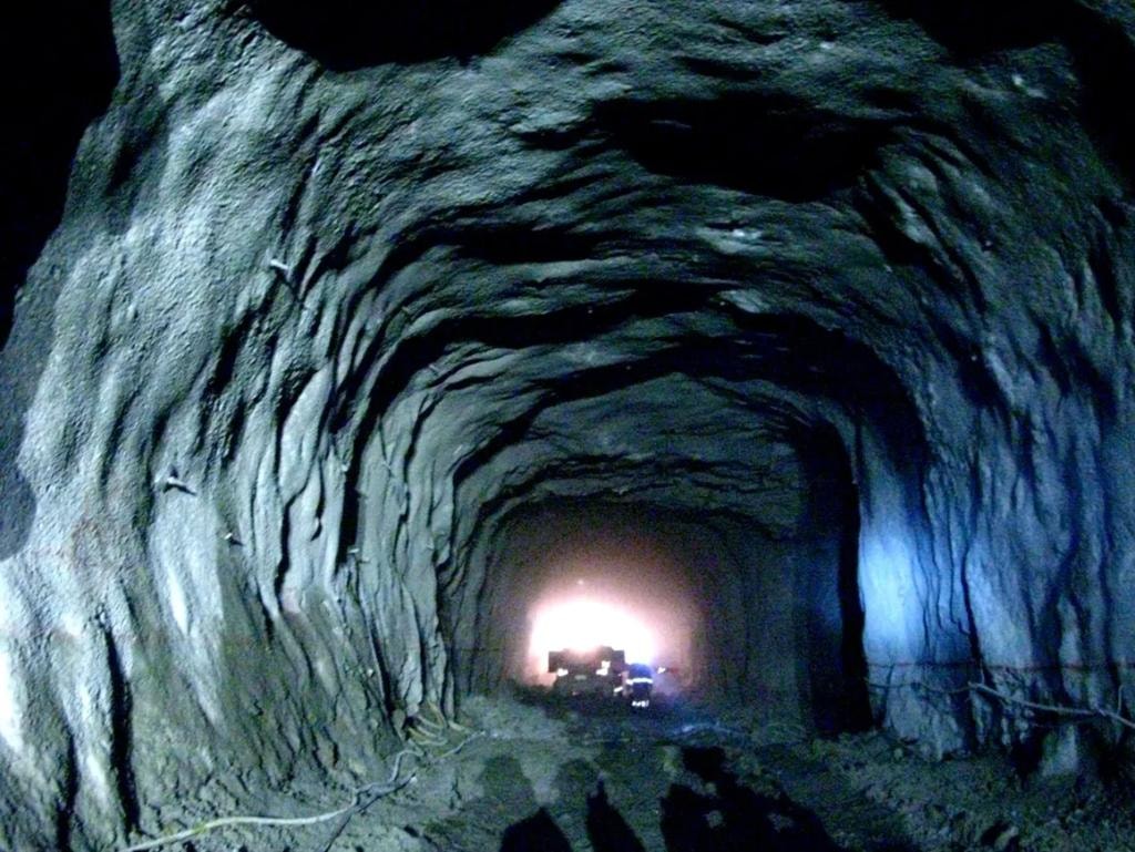 Underground rock tunnel with machinery and lighting
